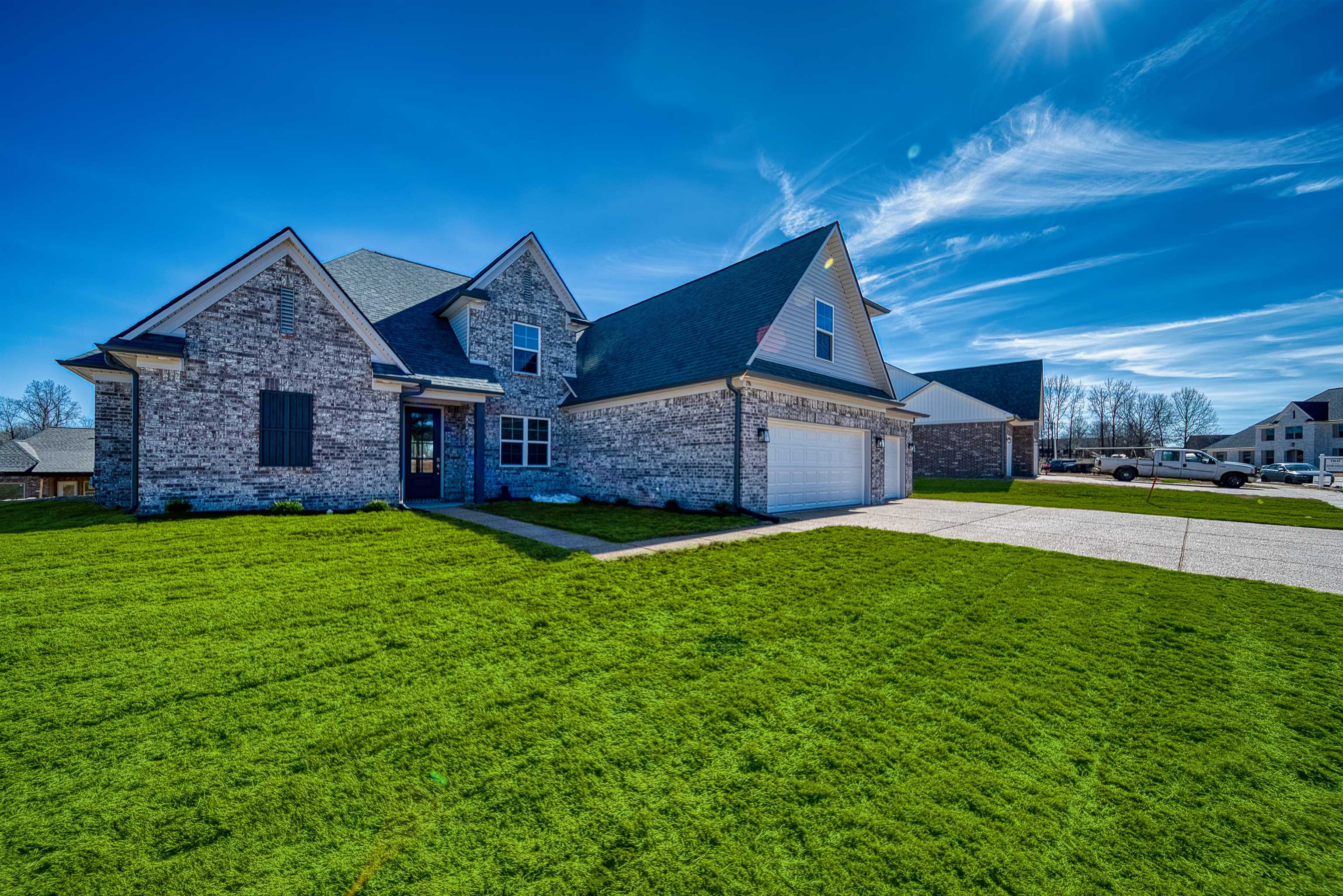 196 Como Lane Atoka, TN 38004 - Photo 1 of 40 View of front facade featuring a front yard, concrete driveway, brick siding, and a shingled roof