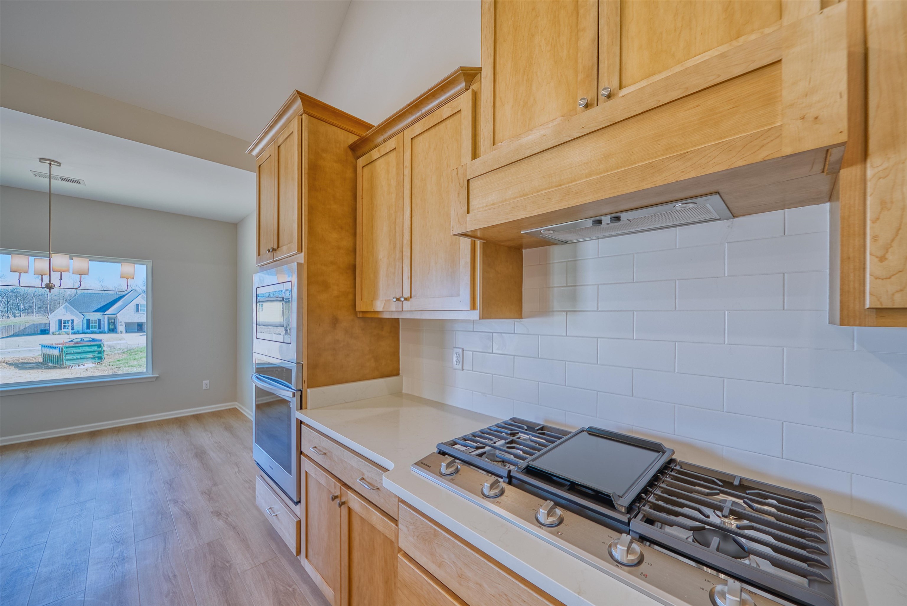 196 Como Lane Atoka, TN 38004 - Photo 17 of 40 Kitchen with stainless steel appliances, light wood finished floors, backsplash, light wood finish cabinetry, and decorative light fixtures