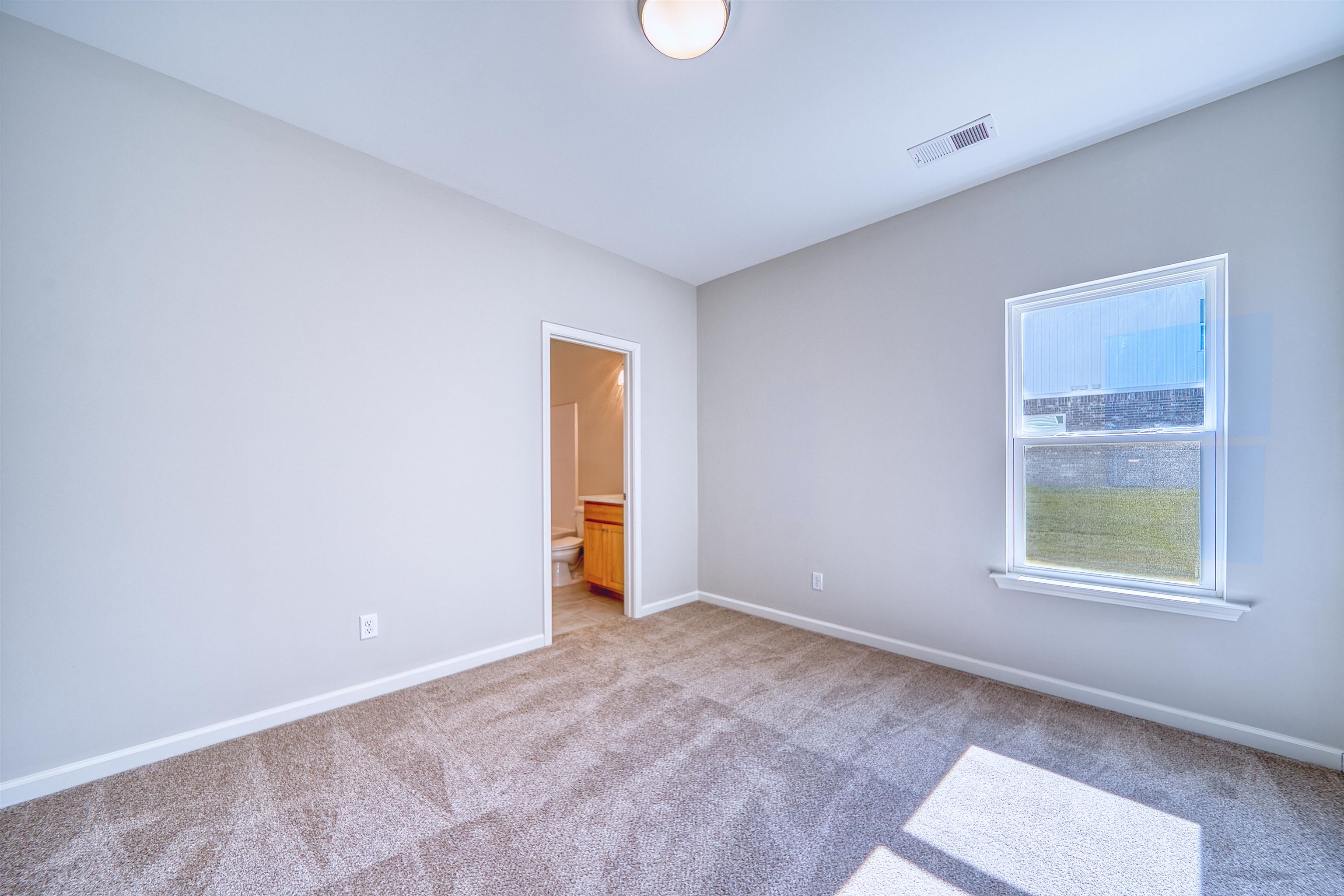 196 Como Lane Atoka, TN 38004 - Photo 20 of 40 Unfurnished bedroom with connected bathroom and carpet floors