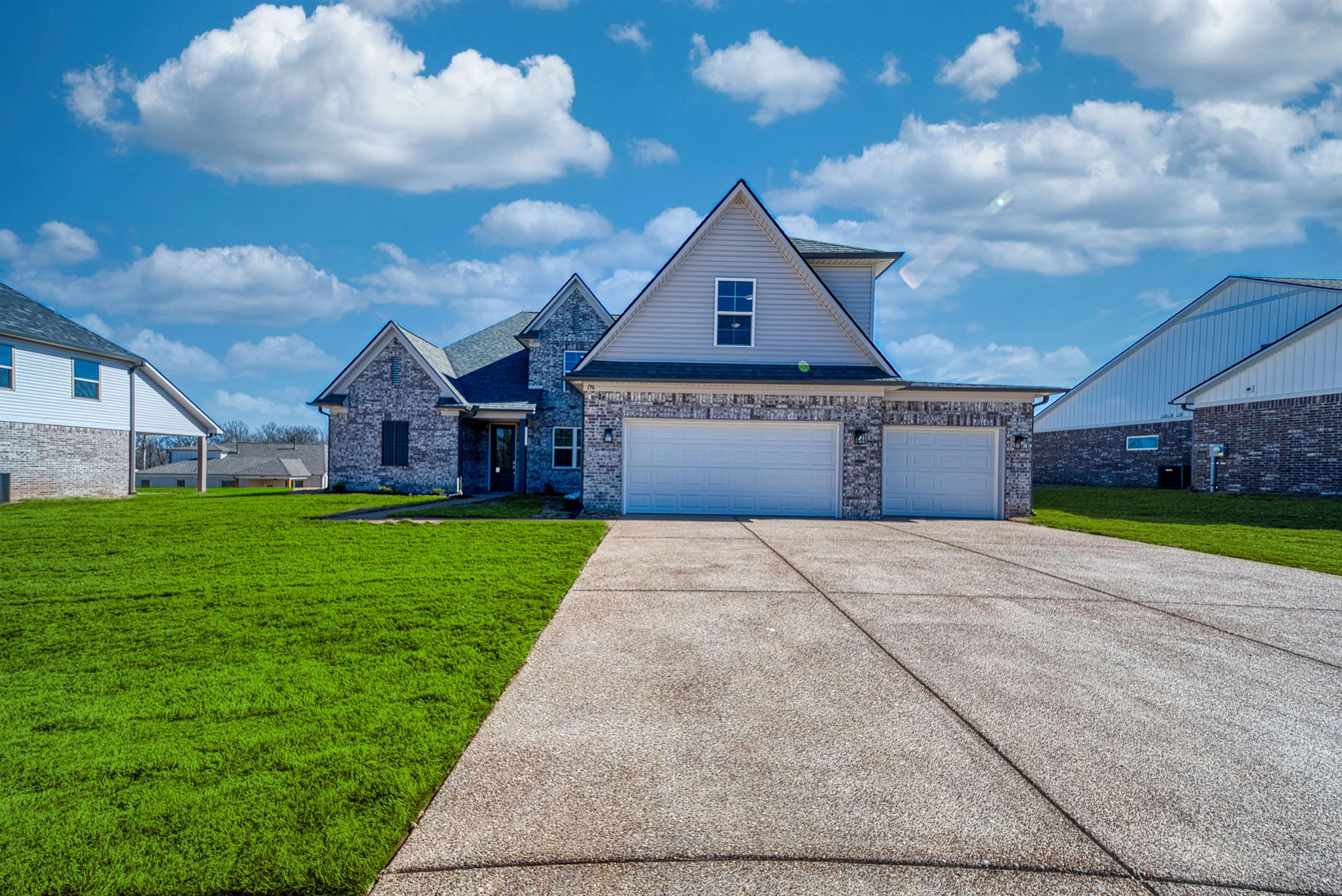 196 Como Lane Atoka, TN 38004 - Photo 29 of 40 View of front of home featuring a front yard, concrete driveway, brick siding, and a garage