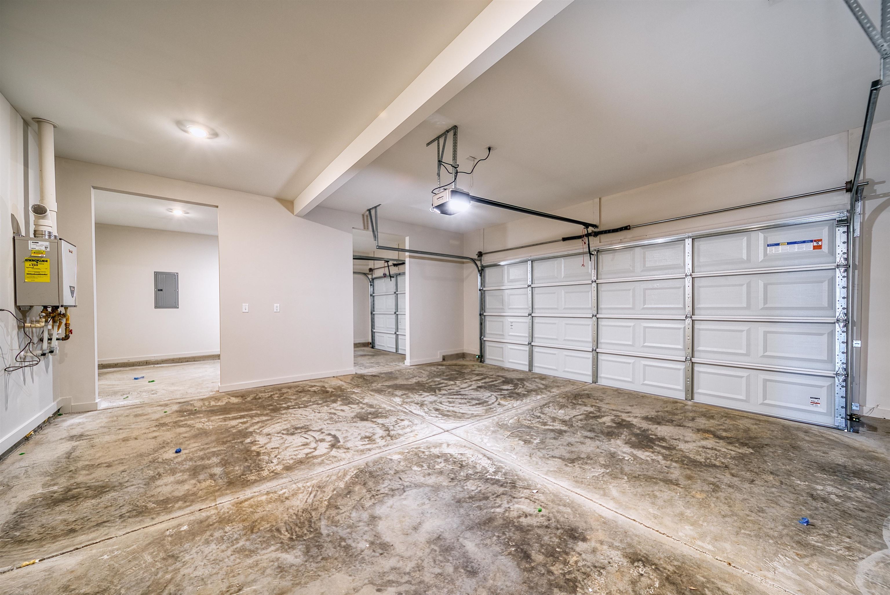 196 Como Lane Atoka, TN 38004 - Photo 36 of 40 Garage featuring electric panel, water heater, and a garage door opener