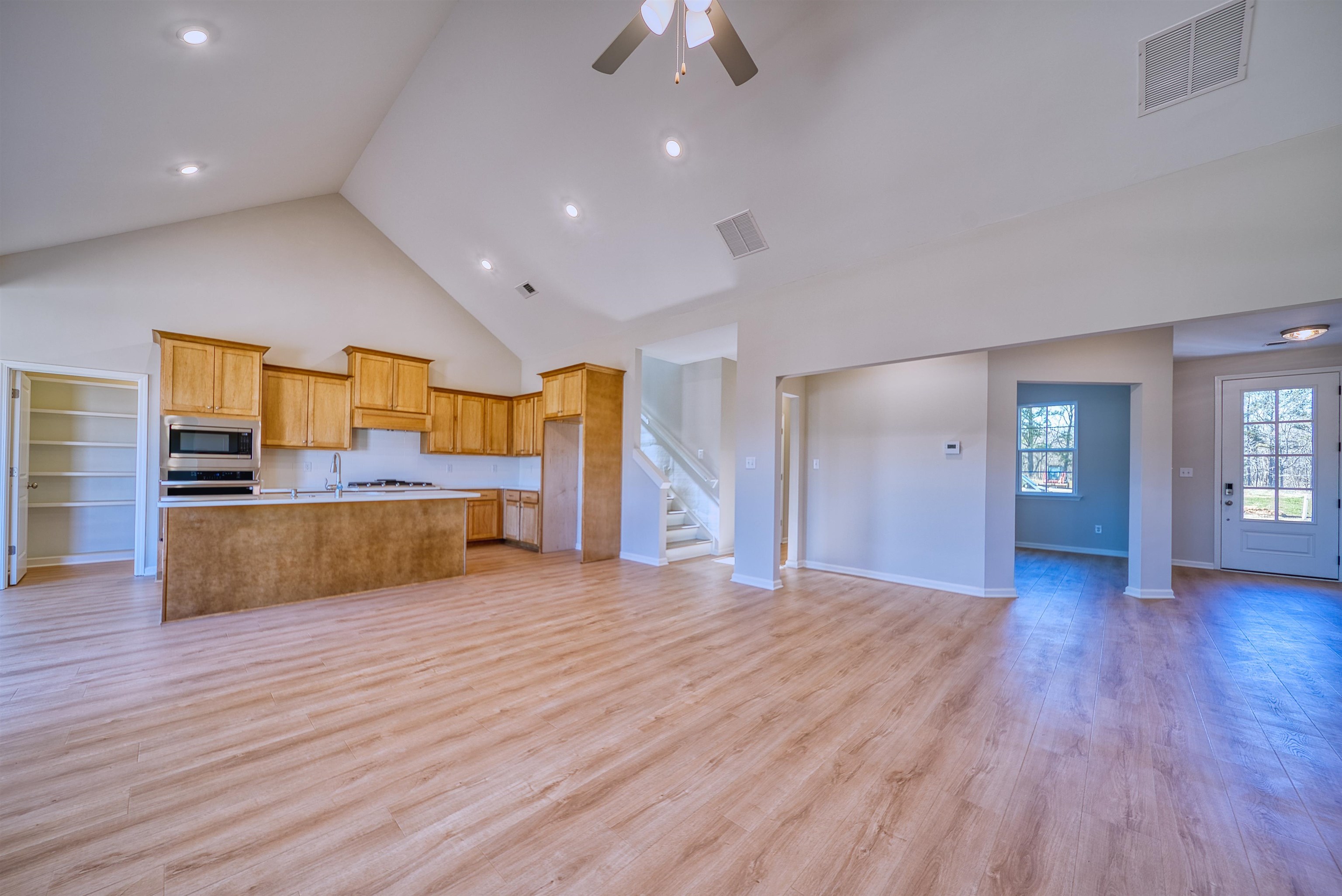 196 Como Lane Atoka, TN 38004 - Photo 38 of 40 Kitchen with open floor plan, a high ceiling, light countertops, light wood finished floors, and a kitchen island with sink