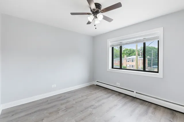 an empty room with a window and a ceiling fan