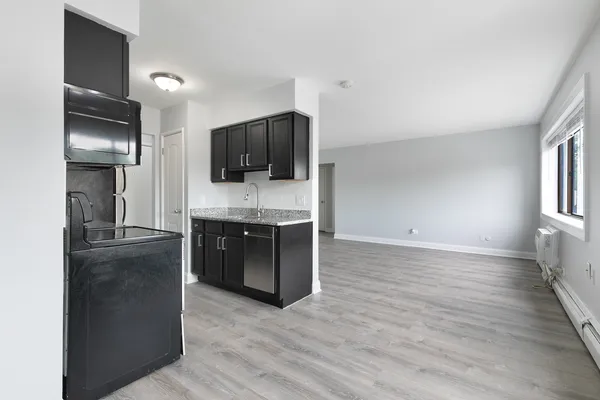 a living room with a flat screen tv a refrigerator and a stove