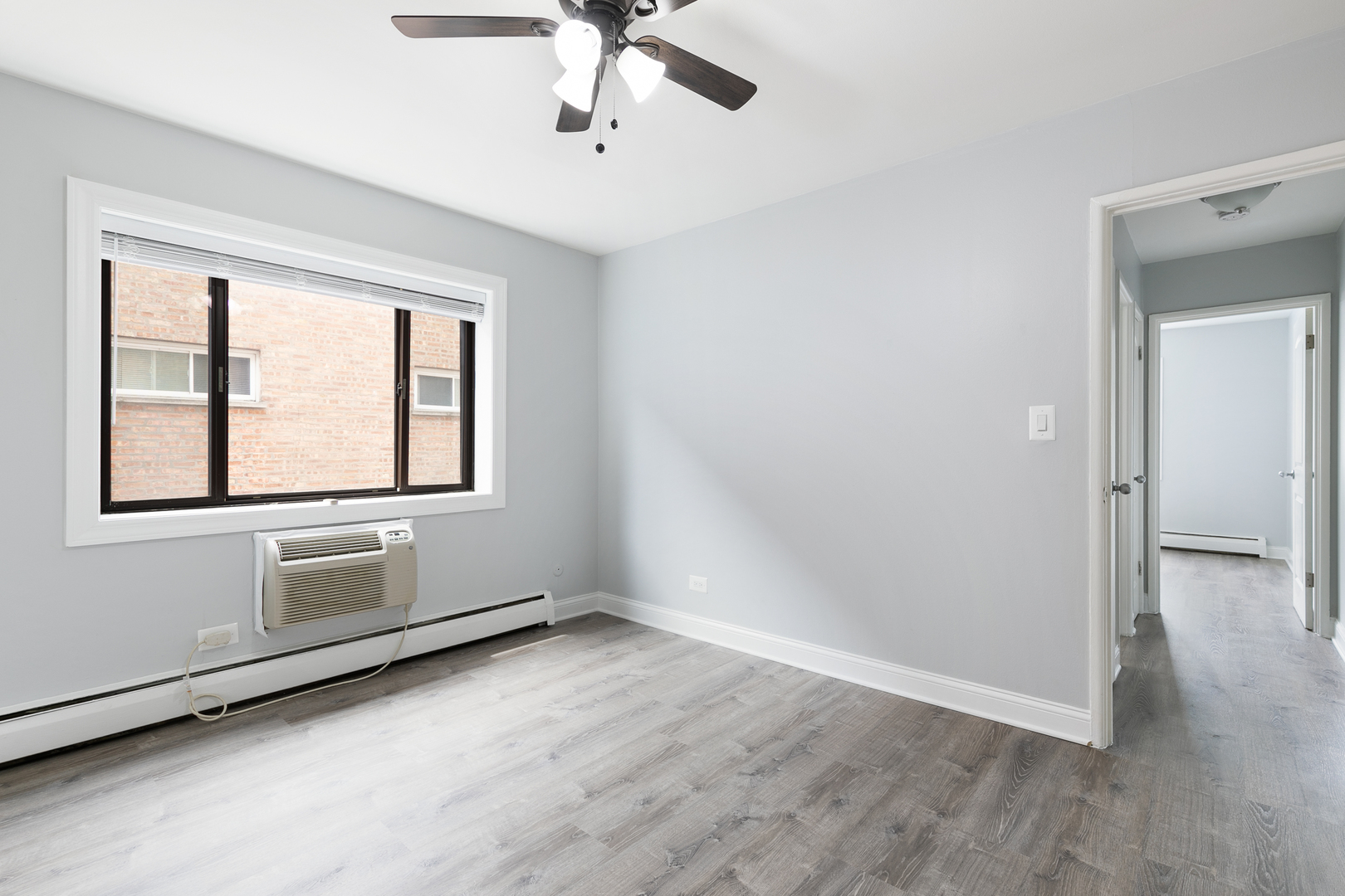 6826 North Ridge Boulevard, Unit 404 Chicago, IL 60645 - Photo 8 of 17 a view of an empty room with a window and wooden floor