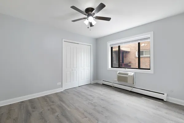 an empty room with windows and fan
