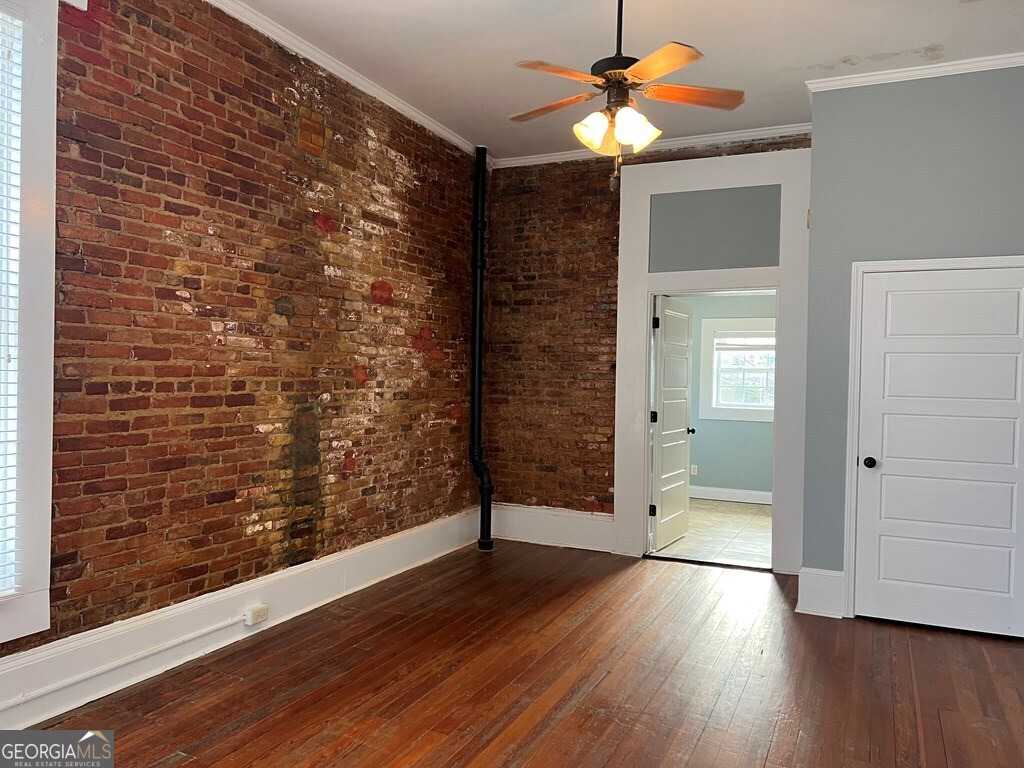 128 West Jackson Street, Unit E Dublin, GA 31021 - Photo 5 of 6 a view of a hallway with wooden floor and chandelier