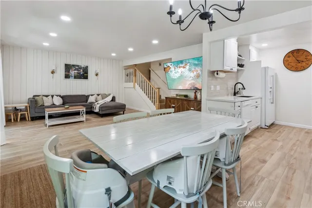 a kitchen with stainless steel appliances kitchen island a table and chairs in it