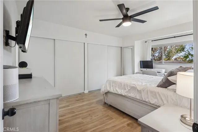 a bedroom with a large bed and a flat tv screen on dresser