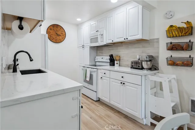 a kitchen with stainless steel appliances granite countertop a white wooden cabinets and a sink