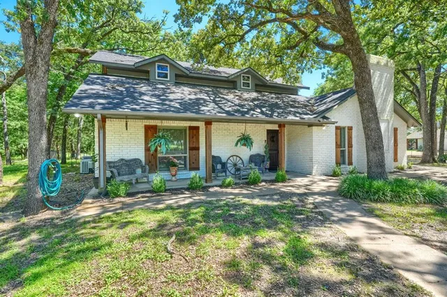 a view of a house with backyard and a large tree