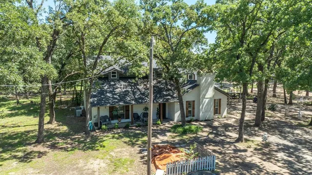 a view of a house with a tree in the yard