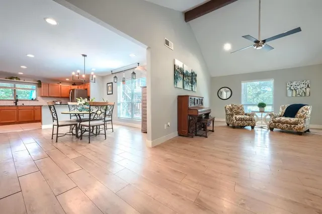 a living room with furniture and a dining table with kitchen view