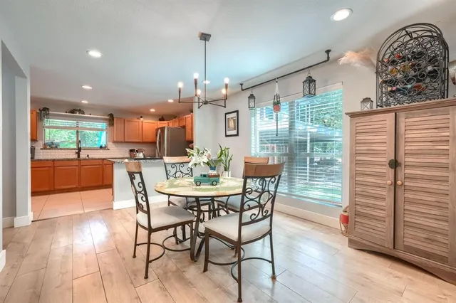 a view of a dining room and livingroom with furniture wooden floor a chandelier