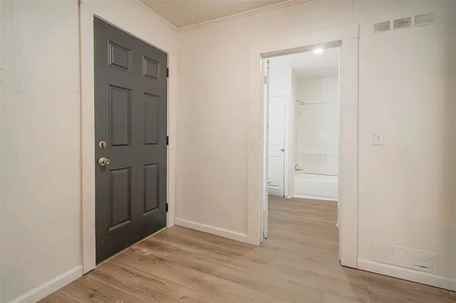 an empty room with wooden floor and closet area
