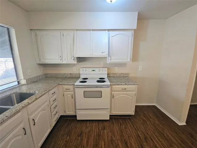 a white kitchen with sink and cabinets