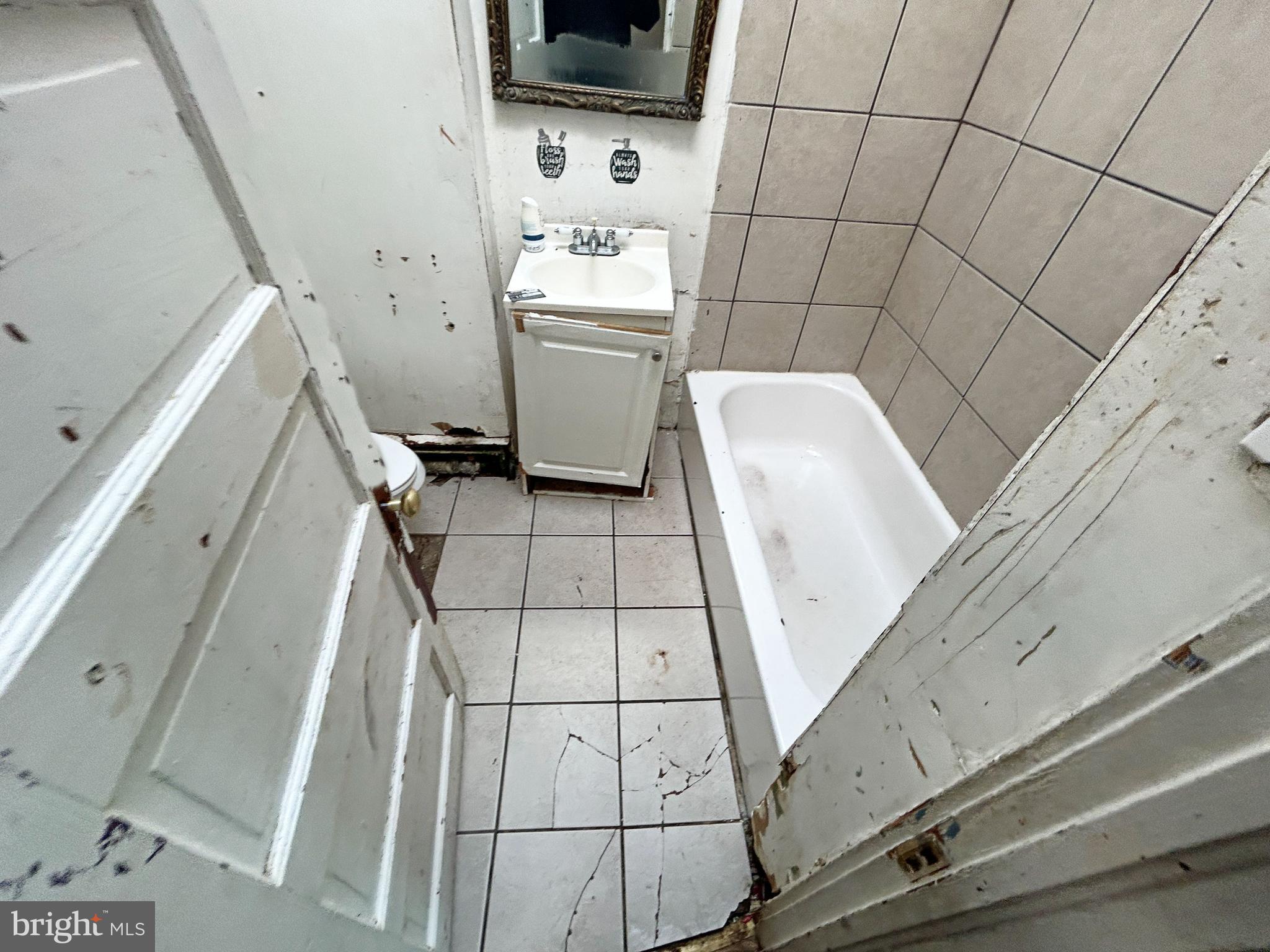 2904 Winchester Street Baltimore, MD 21216 - Photo 16 of 17 a bathroom with a sink a toilet and mirror