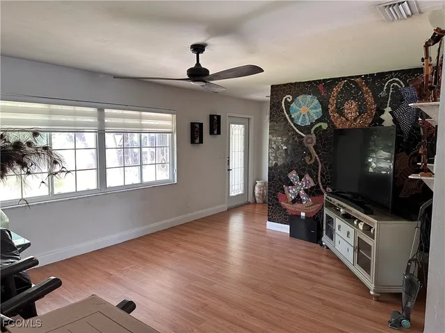 a view of a livingroom with wooden floor and a ceiling fan