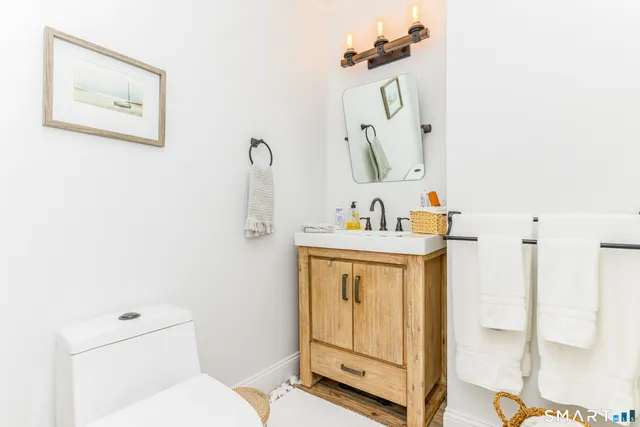 a bathroom with a sink a toilet and mirror