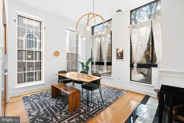 a living room with a table and windows