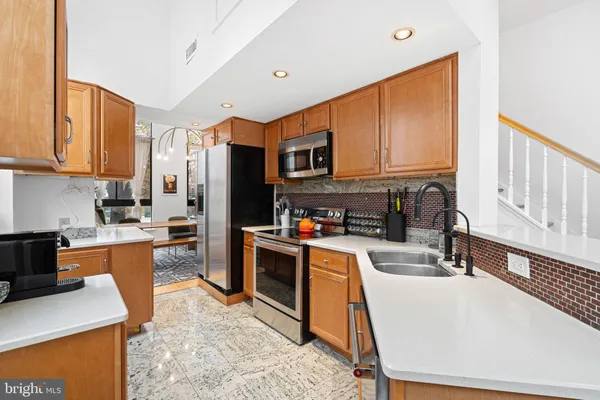 a kitchen with stainless steel appliances granite countertop a stove a sink a refrigerator and a microwave