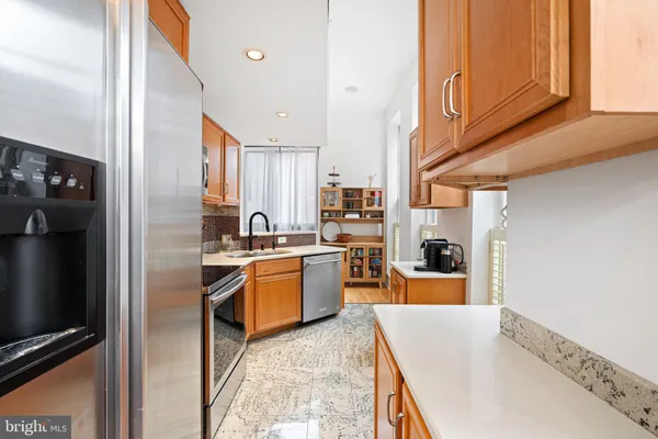 a kitchen with granite countertop a refrigerator stove top oven and sink