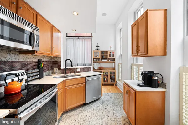 a kitchen with stainless steel appliances a stove a sink a microwave and cabinets