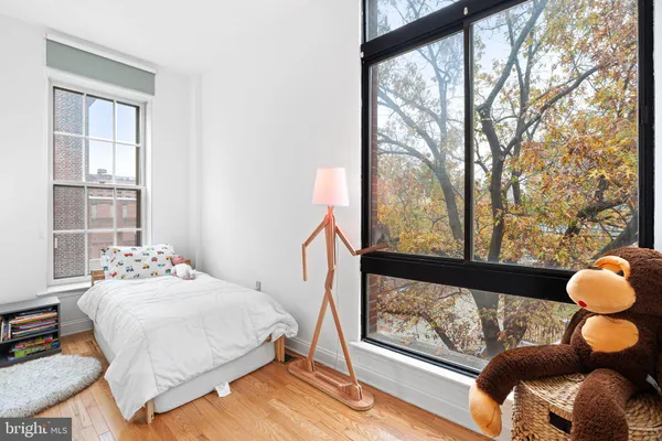 a bedroom with a bed and a large window with outer view