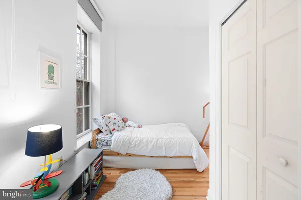 a bedroom with a bed and wooden floor