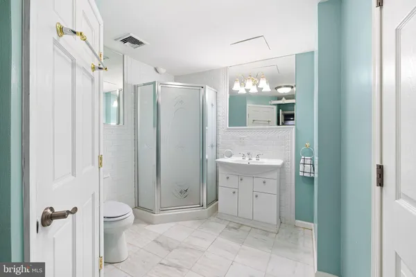 a bathroom with a granite countertop sink mirror and shower
