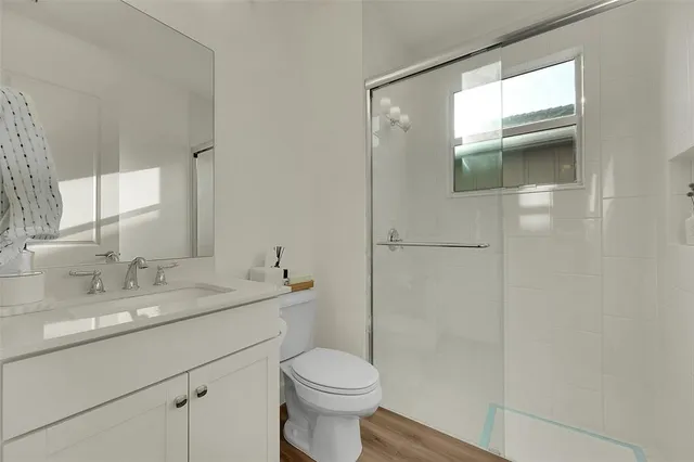 a bathroom with a sink a toilet and shower