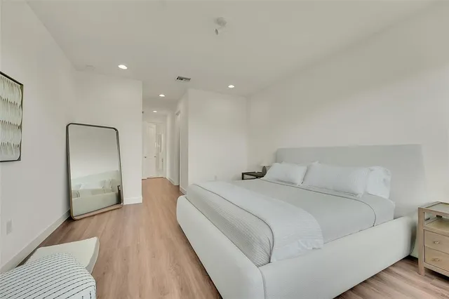 a spacious bedroom with a bed and a large mirror