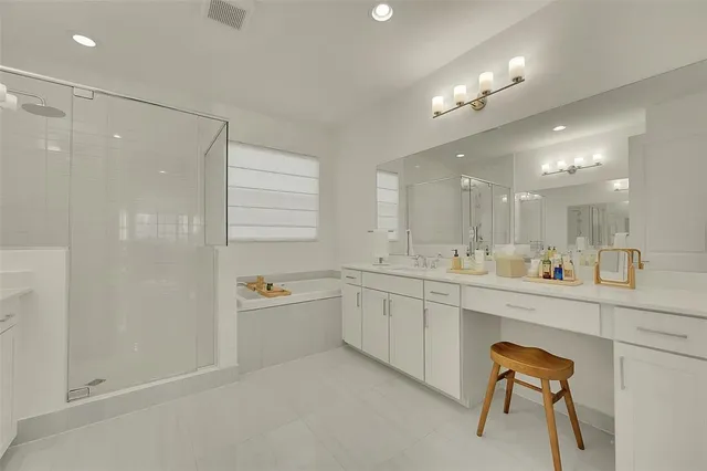 a bathroom with a double vanity sink a mirror and a bathtub