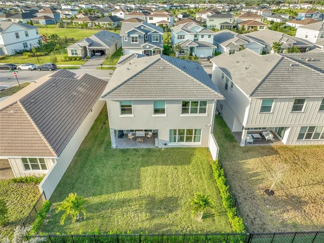 an aerial view of residential houses with outdoor space and ocean view