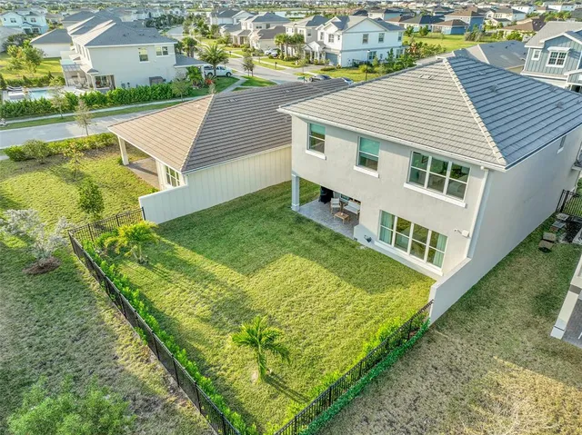 an aerial view of residential houses with outdoor space and ocean view