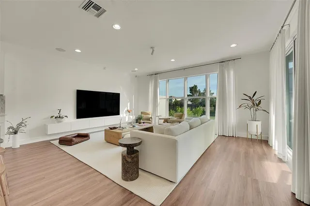 a living room with furniture wooden floor and a flat screen tv