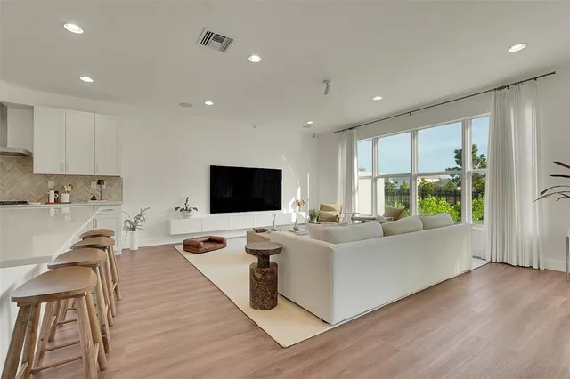 a living room with furniture flat screen tv and a large window