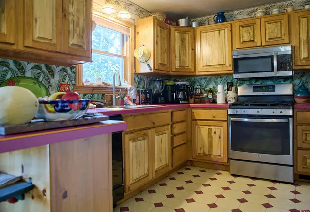 a kitchen with stainless steel appliances granite countertop a stove a sink and a microwave