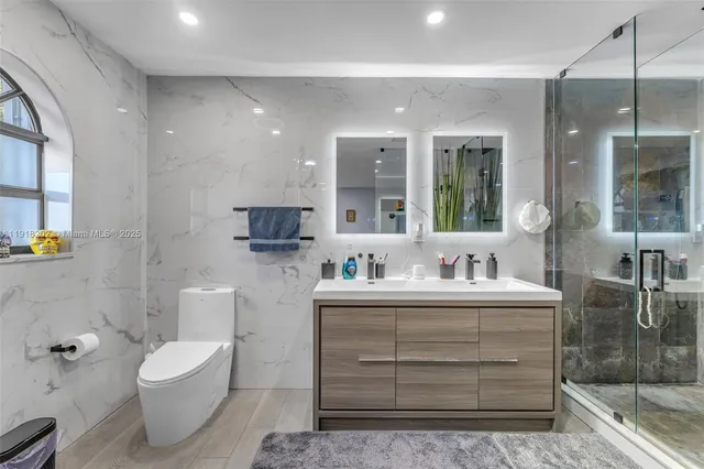 a bathroom with a toilet a sink and mirror