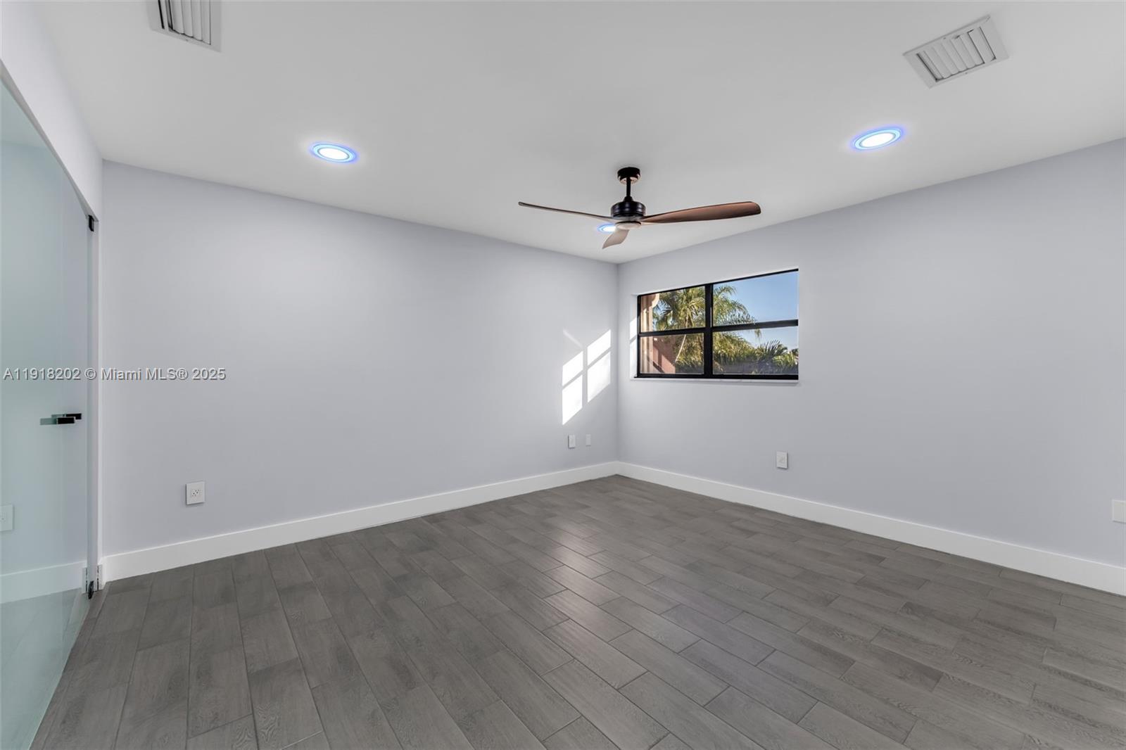 11830 Southwest 104th Lane Miami, FL 33186 - Photo 25 of 48 an empty room with wooden floor and windows