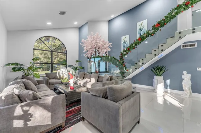 a living room with furniture flowers and a chandelier
