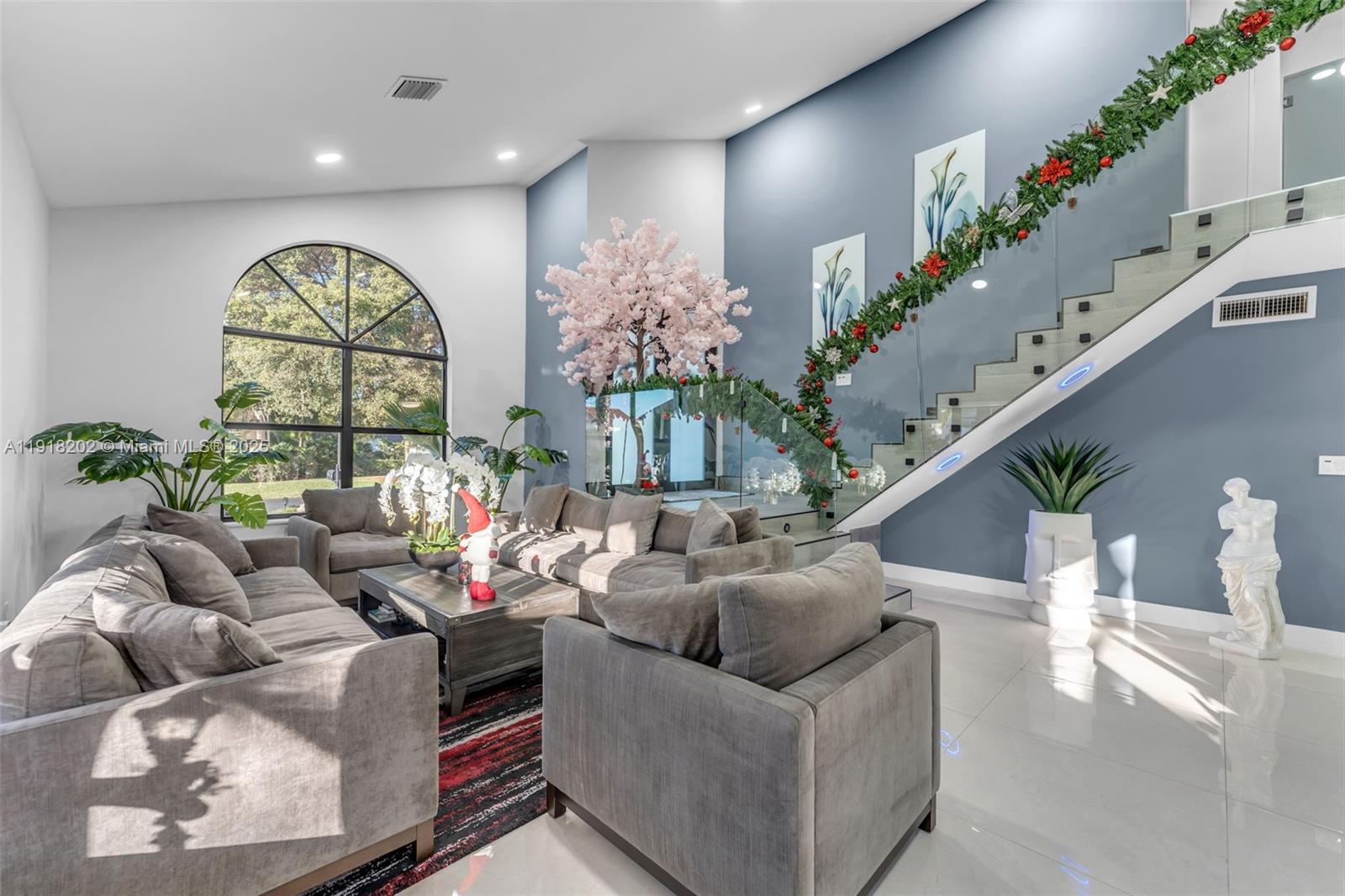 11830 Southwest 104th Lane Miami, FL 33186 - Photo 8 of 48 a living room with furniture flowers and a chandelier