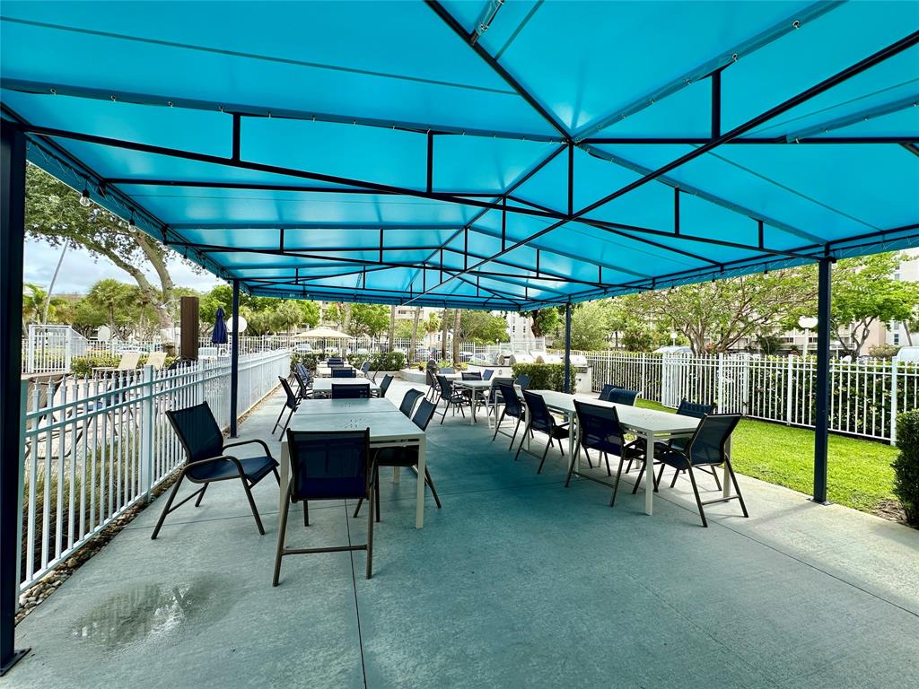 2671 South Course Drive, Unit 802 Pompano Beach, FL 33069 - Photo 25 of 34 a view of a patio with table and chairs under an umbrella