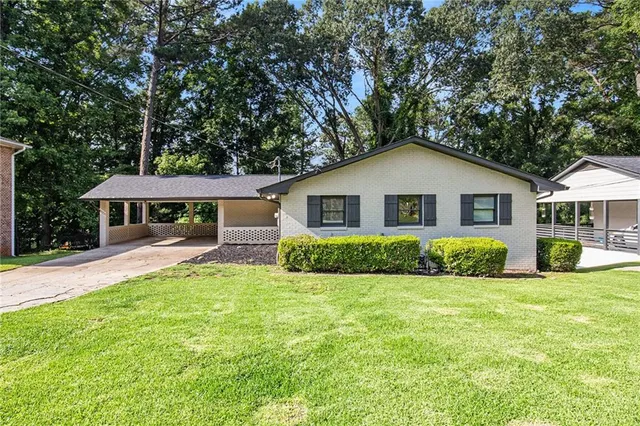 a front view of a house with yard and green space