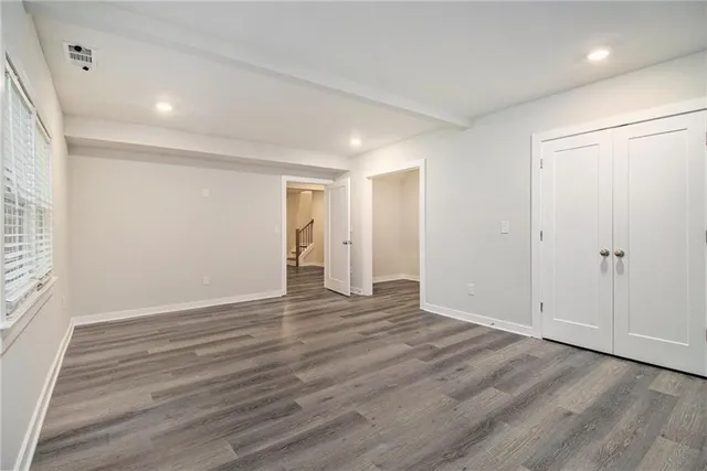 a view of an empty room with wooden floor