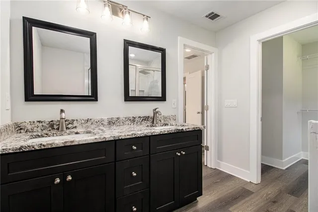 a bathroom with a granite countertop sink vanity and mirror