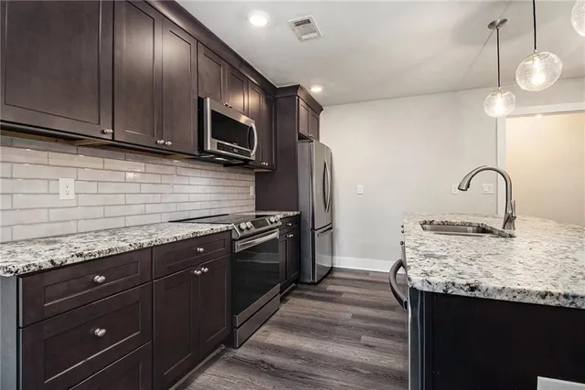 a kitchen with granite countertop stainless steel appliances and wooden cabinets