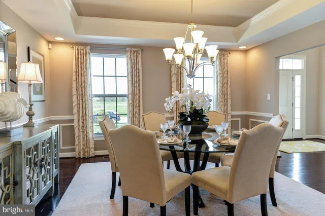 a dining room with furniture a chandelier and wooden floor