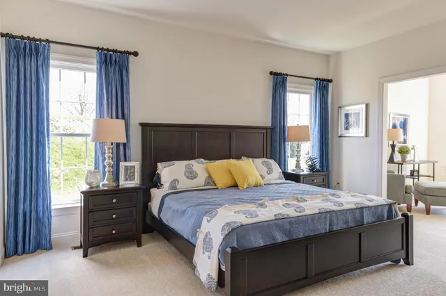 a bedroom with a bed and a dresser next to a window