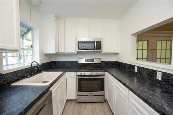 a kitchen with a sink stove top oven and microwave